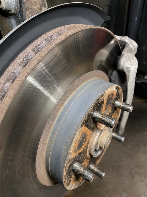 A worn brake rotor and caliper at DAVID's Auto Care in Sioux Falls
