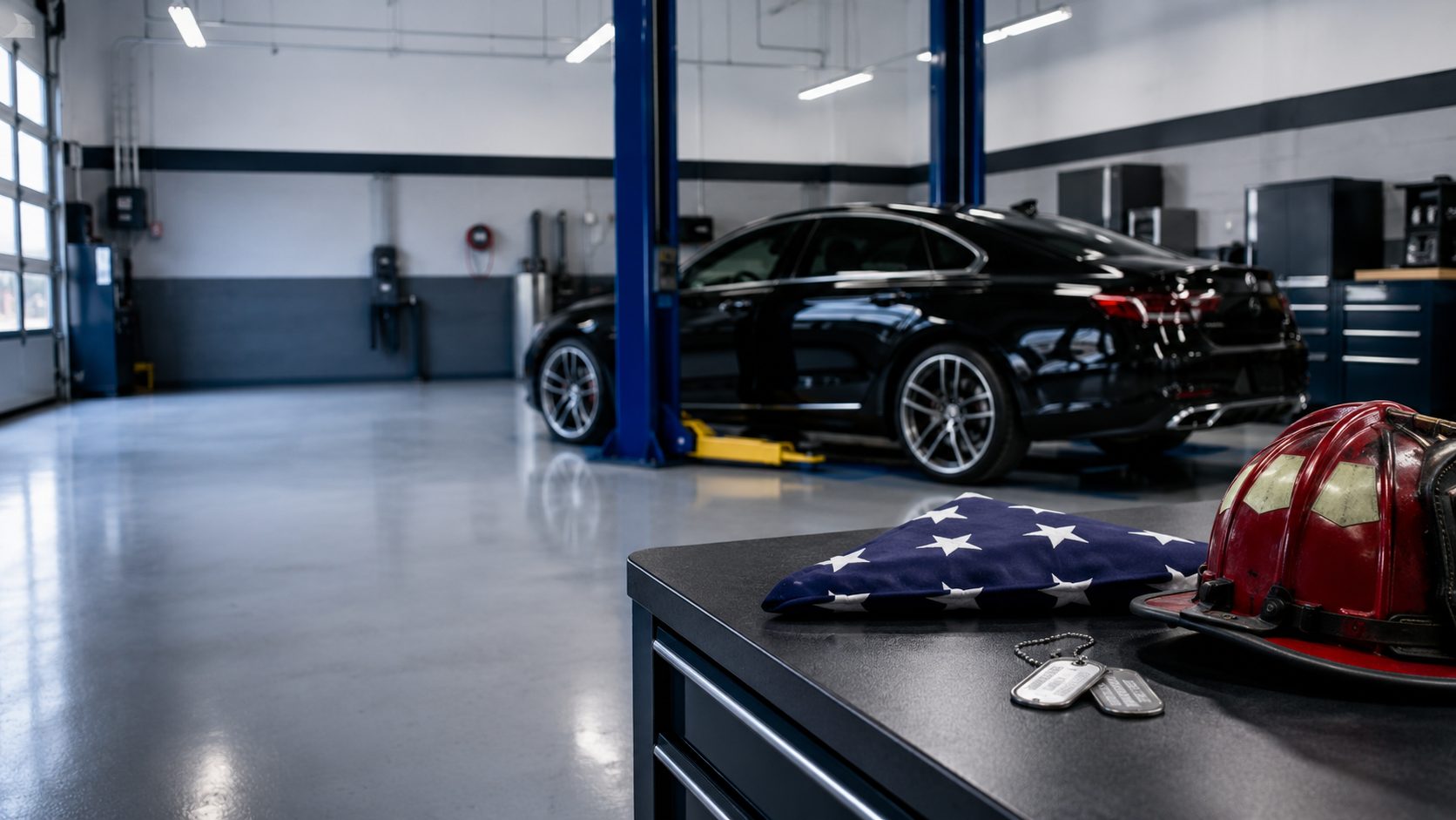 A folded flag, dog tags, and a fire helmet on the bench at DAVID's Auto Care