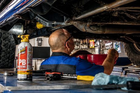 Draining the oil under a raised truck at DAVID's Auto Care