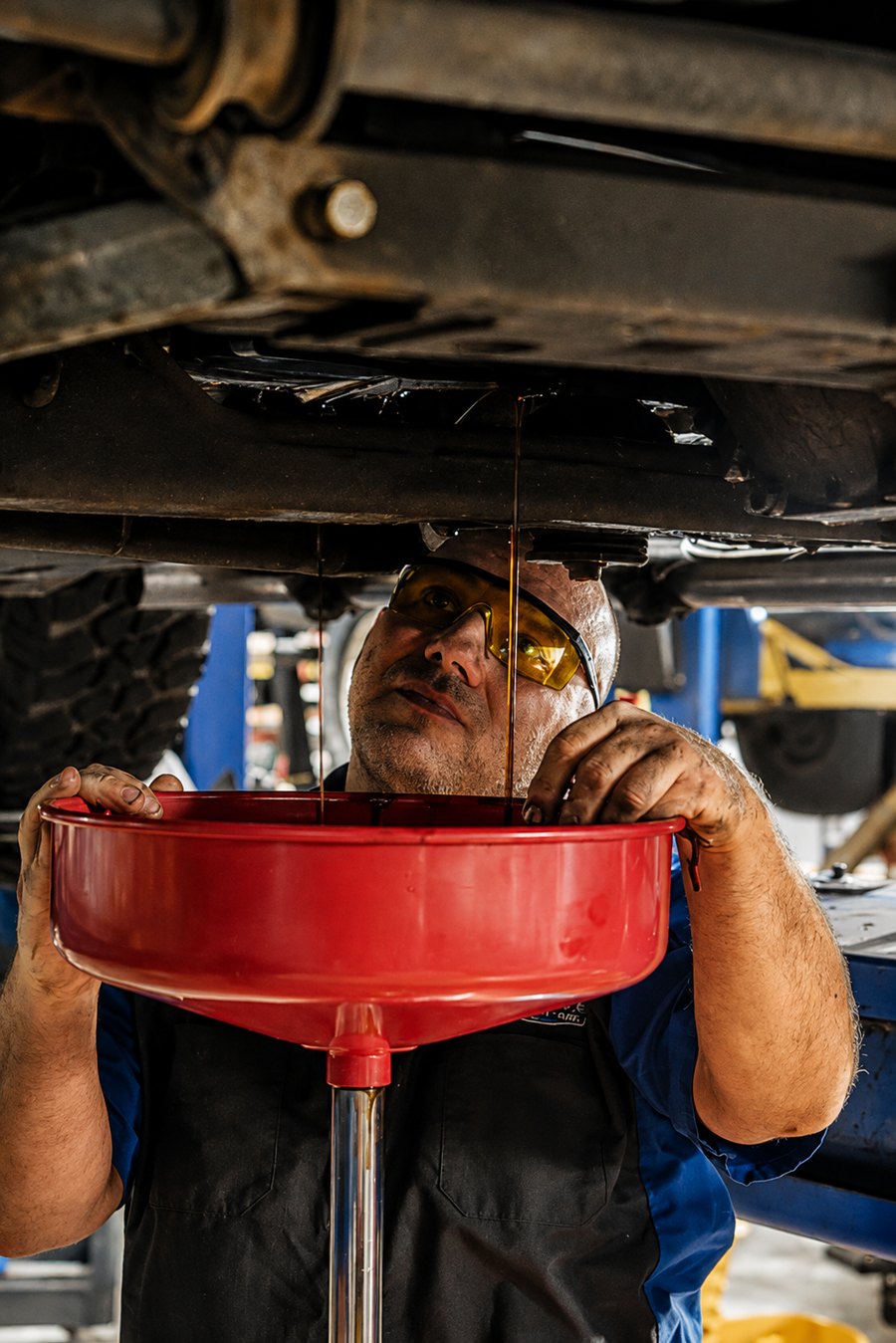 Draining the oil under a raised vehicle at DAVID's Auto Care in Sioux Falls